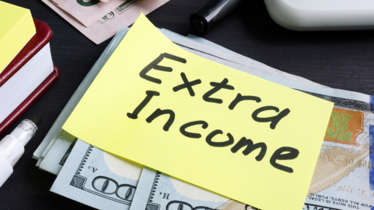 An image of cash with a yellow sticky note on it that says "extra income"