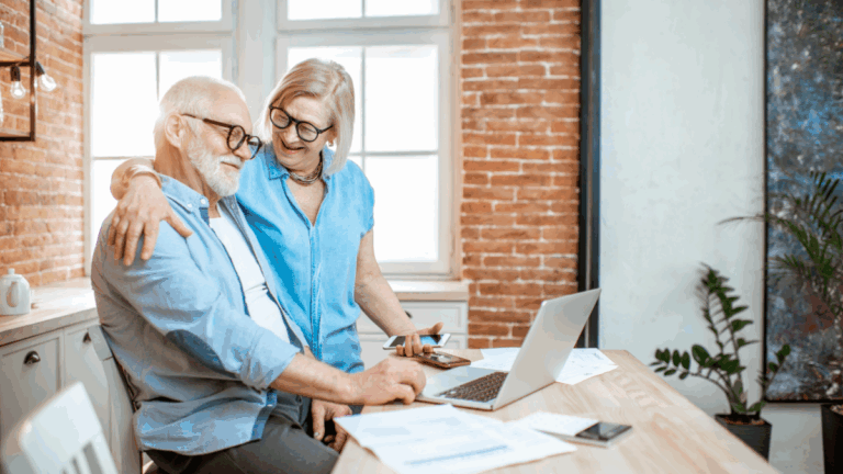 An elderly couple looking at a computer screen and smiling