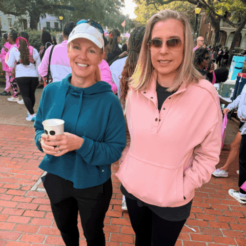 Two Avizo employees smiling, preparing to participate in a breast cancer walk.