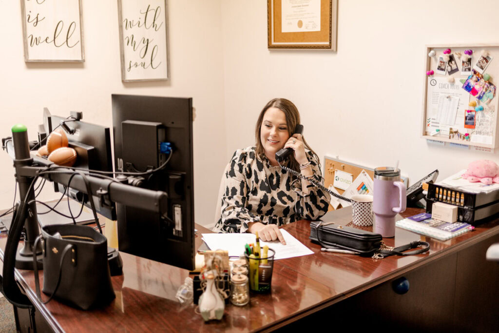 Kirsten Owens at her desk, talking on the phone
