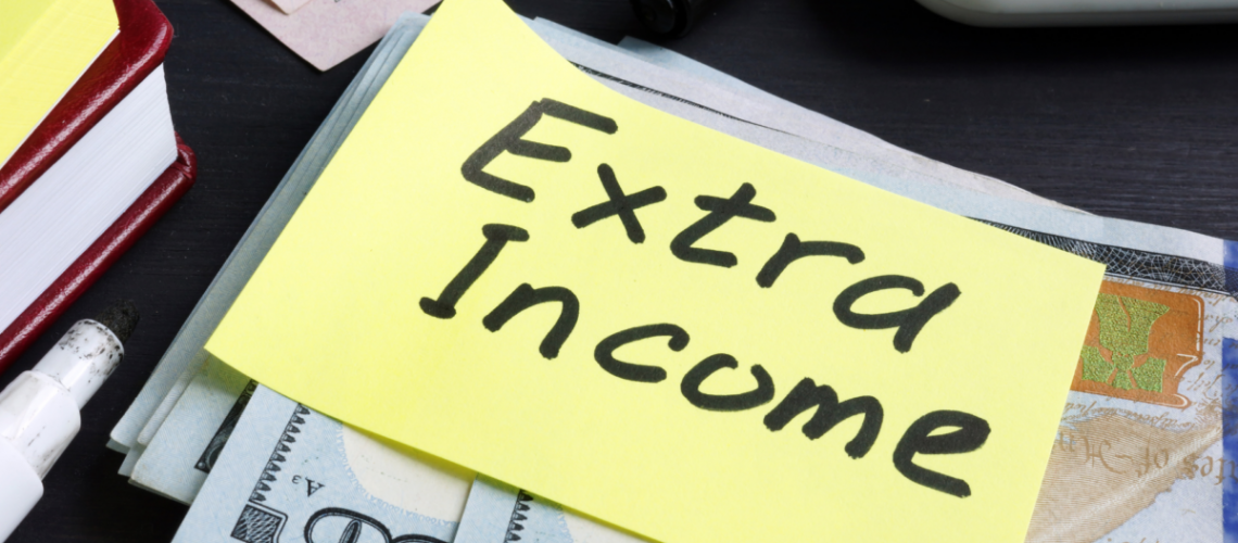 An image of cash with a yellow sticky note on it that says "extra income"