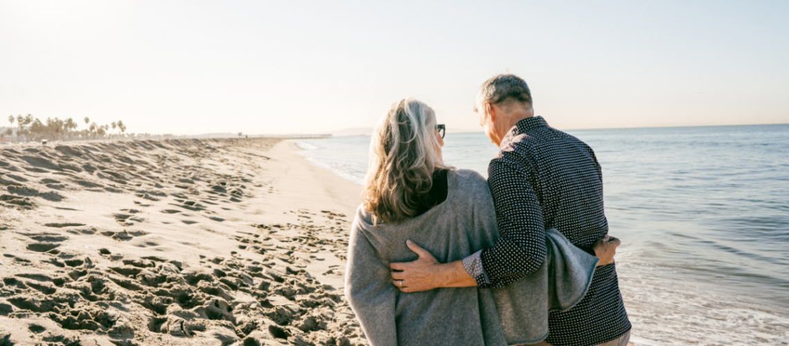 An older couple walking on the beach