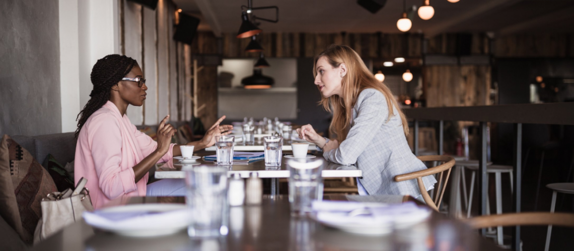 Two women sitting at a table eating lunch